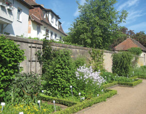 Der Fuchsgarten ist von hohen Mauern umgeben, die Beete sind streng geometrisch angelegt und mit Buchshecken eingefasst. 